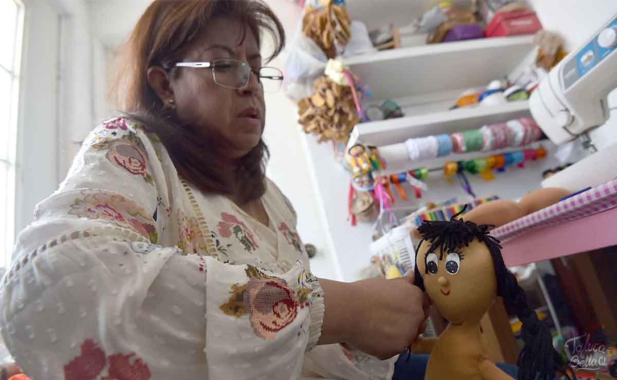 Mujer emprendedora realizando muñecas con su apoyo salario rosa