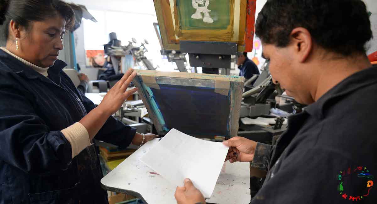 personas trabajan impresión de serigrafia en taller de impresión en toluca
