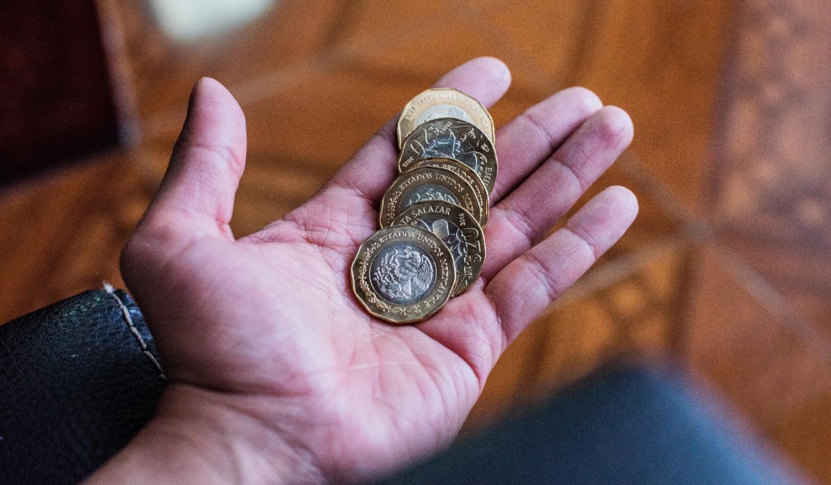 Monedas de $20 pesos en una mano